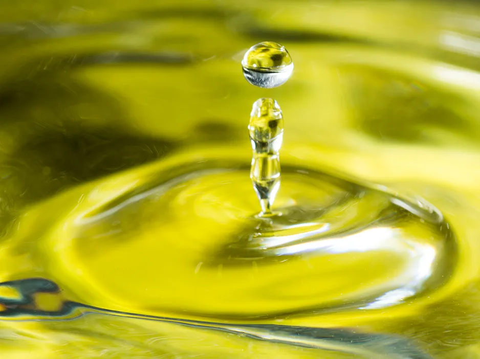 Gota cayendo sobre aceite de oliva virgen extra